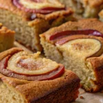 Moist apple fritter cake slices topped with baked apple rounds and cinnamon sugar