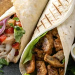 Delicious chicken shawarma wraps served with garlic sauces and fresh vegetables on a dark plate