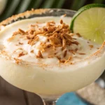Creamy Coconut Lime Daiquiri garnished with toasted coconut and lime slice
