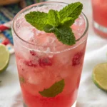 Pink Coconut Mojito garnished with mint and served with lime slices on a summer table